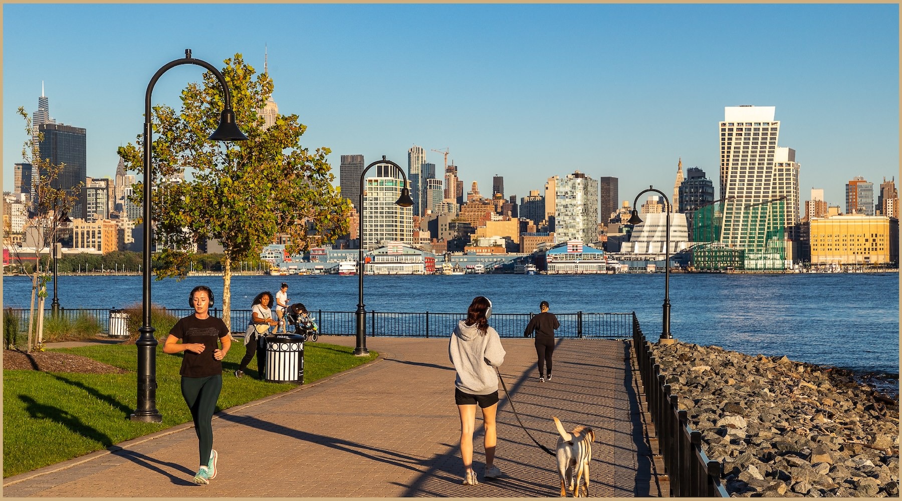Close to the center of everything people in a park with a body of water and city in the background