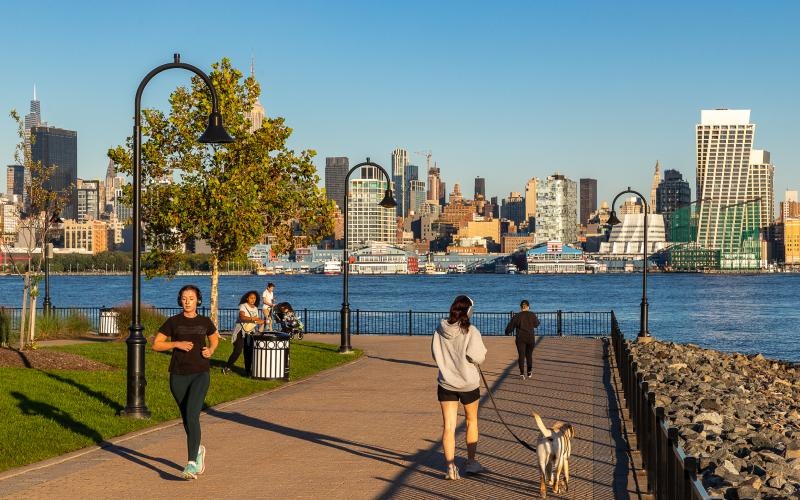people walking and jogging through park along the waterfront